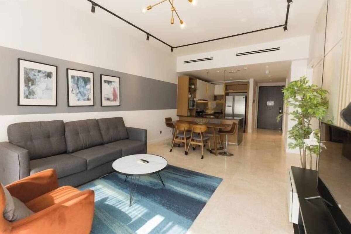 Una sala de estar moderna con un sofá, una mesa de centro y una obra de arte en la pared.