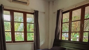 Un dormitorio con cama, cortinas y ventanas.