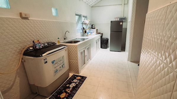 Una cocina compacta con estufa integrada, lavaplatos y refrigerador.
