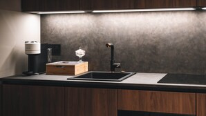 A modern kitchen with a built-in dishwasher, a coffee machine, and a glass container on the countertop. - Exceptional Victoire apartment (Épinal)
