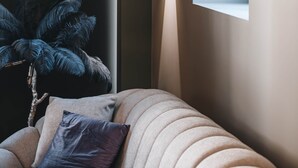 Een modern interieur met een bank, een kamerplant en een wandlamp.