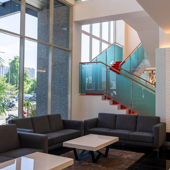 A modern interior with a staircase, large windows, and seating area. - Hotel Tamara Melaka (Malacca City)