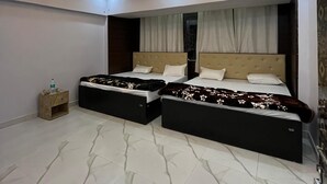 Un dormitorio moderno con dos camas, una mesita de noche y un techo decorativo.