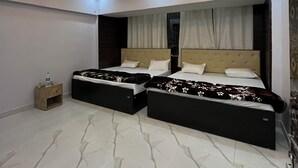 Un dormitorio moderno con dos camas, una mesita de noche y un techo decorativo.