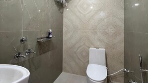 Un baño con inodoro, lavabo, ducha y bidé.