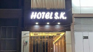 Un edificio con un letrero que dice "HOTEL S.K." y un logotipo encima del letrero.