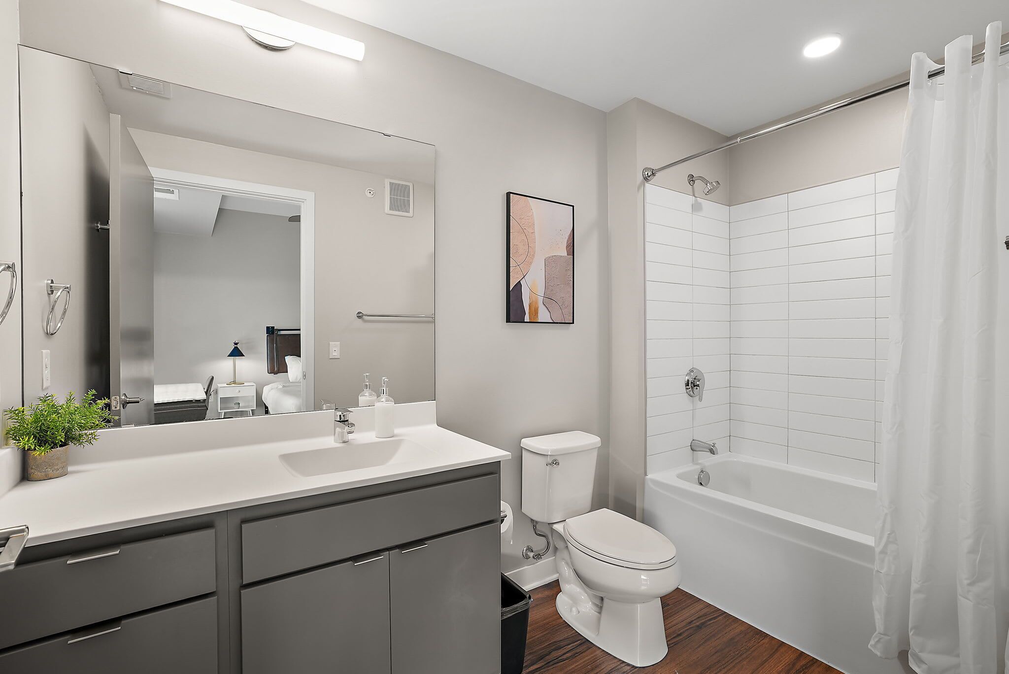 A modern bathroom with a white sink, toilet, and bathtub.