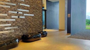 A modern lobby with a stone wall, a glass door, and a 'No Smoking' sign. - Lakeville KL Taman Wahyu City Centre [3Bedroom Sleep 5] (Kuala Lumpur)