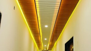 A hallway with a wooden ceiling and yellow lighting. - Ram Basant Hotel & Resturant (Danta Ramgarh)