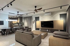 Una sala moderna con televisor de pantalla plana, sofá y comedor.