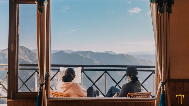 A room with a large window overlooking a mountainous landscape. - Hilltop Resort, Narkanda (Theog)