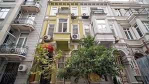 A multi-story building with balconies, air conditioning units, and a tree in front. - New Life Taksim Hotel (Istanbul)