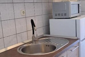 Kühlschrank, Mikrowelle, Herdplatte, Esstisch