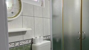 A bathroom with a toilet, sink, and a mirror with a decorative frame. - Apartments Natali - One Bedroom Apartment with Balcony (APP6) (Podaca)
