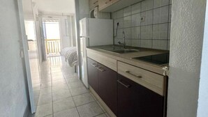 A narrow kitchen with a sink, cabinets, and a refrigerator. - Apartments Natali - One Bedroom Apartment with Balcony (APP6) (Podaca)
