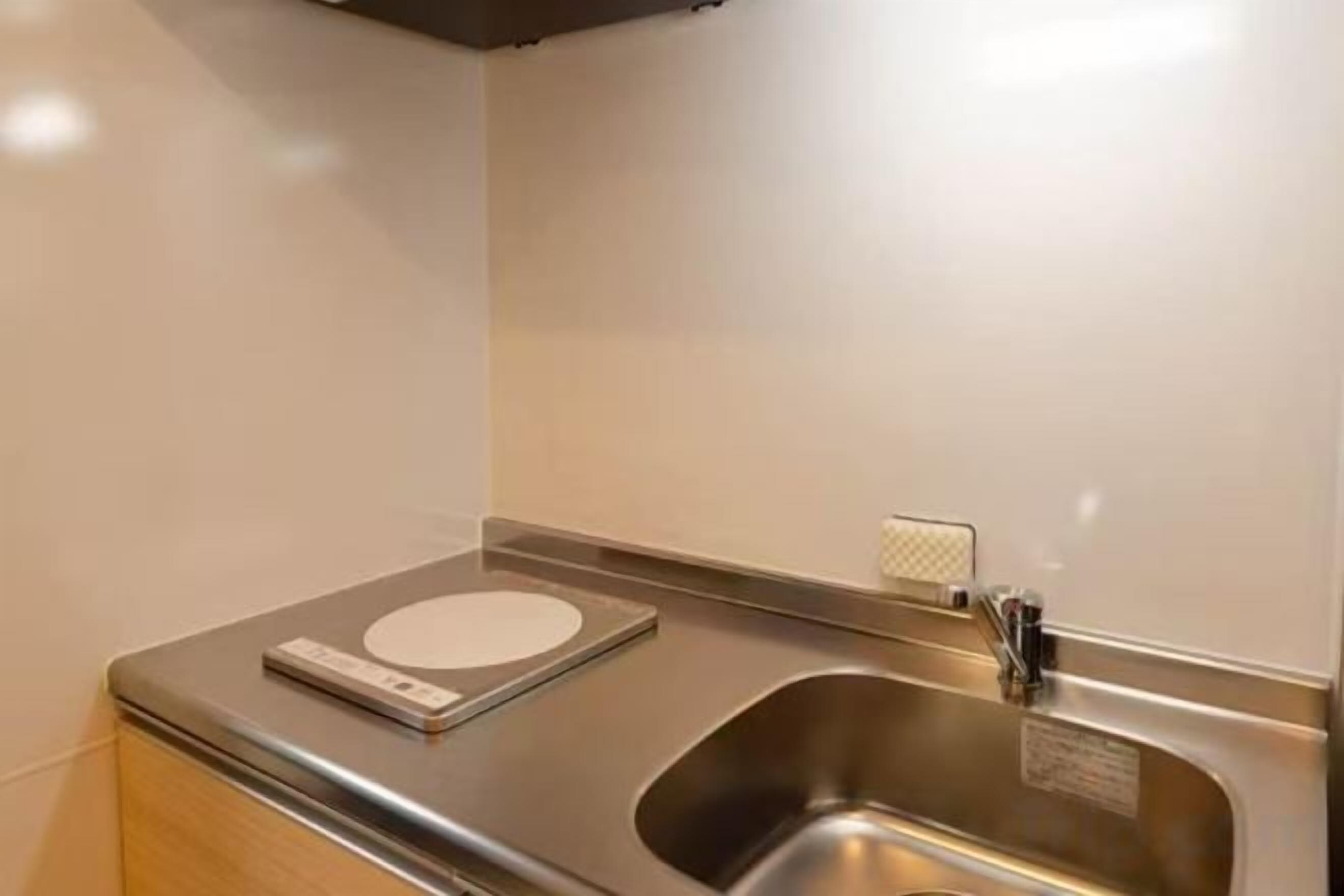 A stainless steel sink with a faucet and a scale on the countertop.