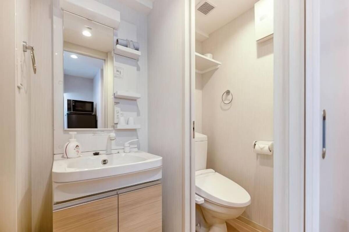 A bathroom with a white sink, mirror, and toilet.