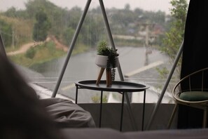 A window with a view of a landscape, a small table with a plant, and a chair. - The Haus at Khaokho (Khao Kho)