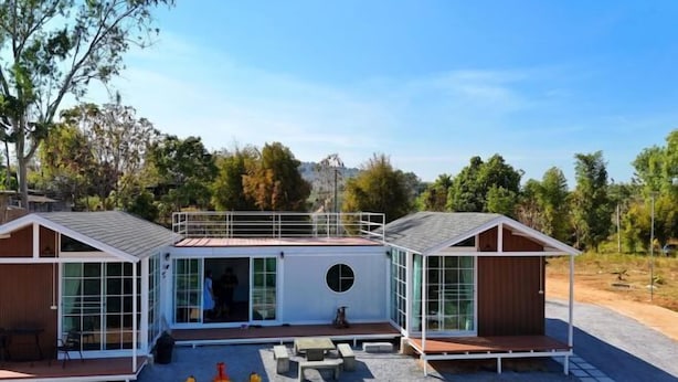 A modern house with a central circular window, two side extensions, and a covered outdoor area with seating. - The Haus at Khaokho (Khao Kho)