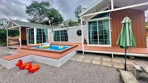 A modern house with a swimming pool, a covered patio, and a green umbrella. - The Haus at Khaokho (Khao Kho)