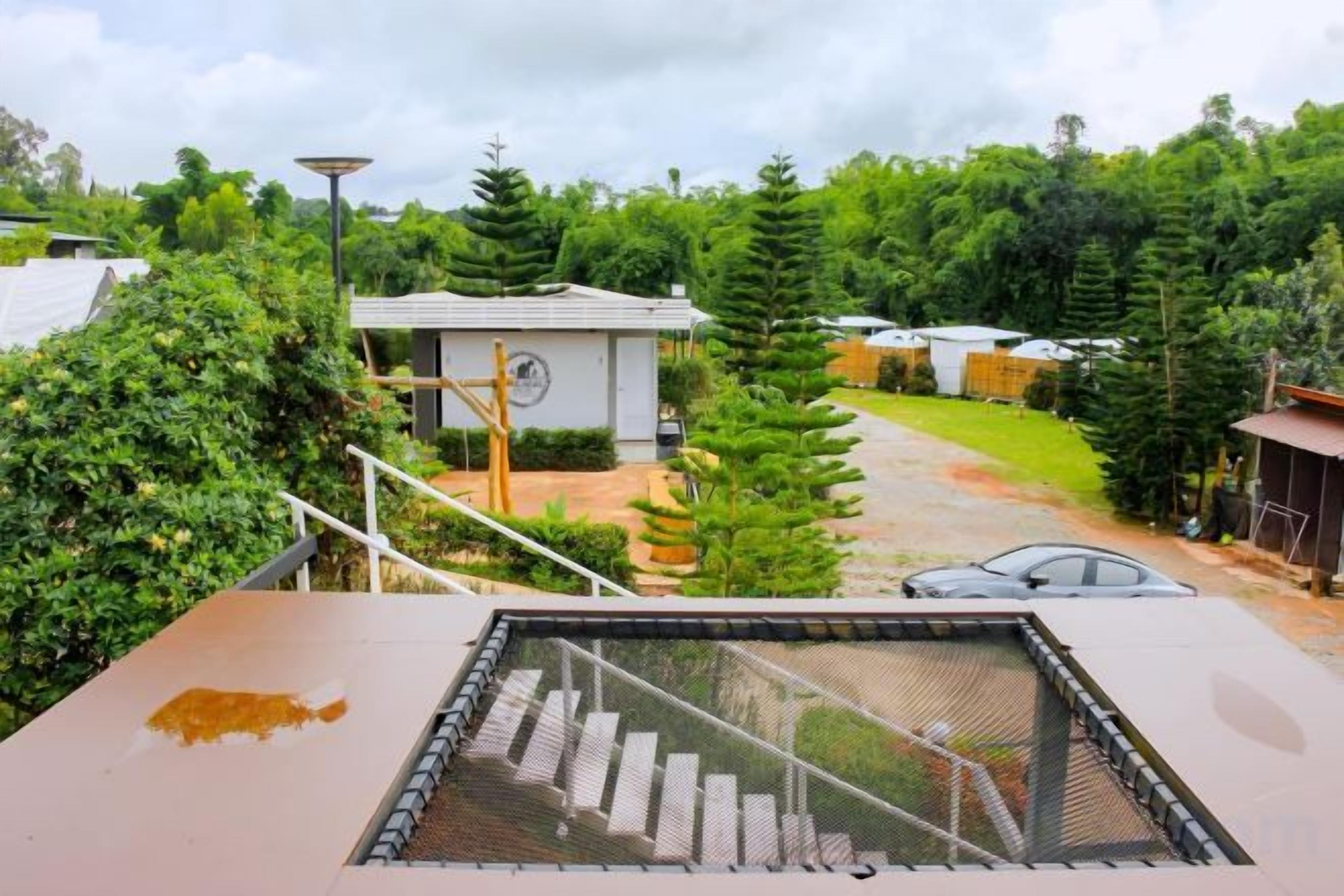 A residential property with a covered outdoor area, a small utility shed, and a well-maintained garden.