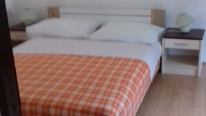 A bedroom with a bed, a nightstand, and a drawer unit. - Apartments Rubbi - Studio with Terrace (Vrsi)