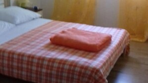 A bed with a checkered bedspread and a folded blanket. - Apartments Rubbi - Studio with Terrace (Vrsi)