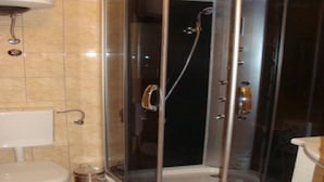 Een moderne badkamer met een douchecabine van glas, een toilet en een wastafel.