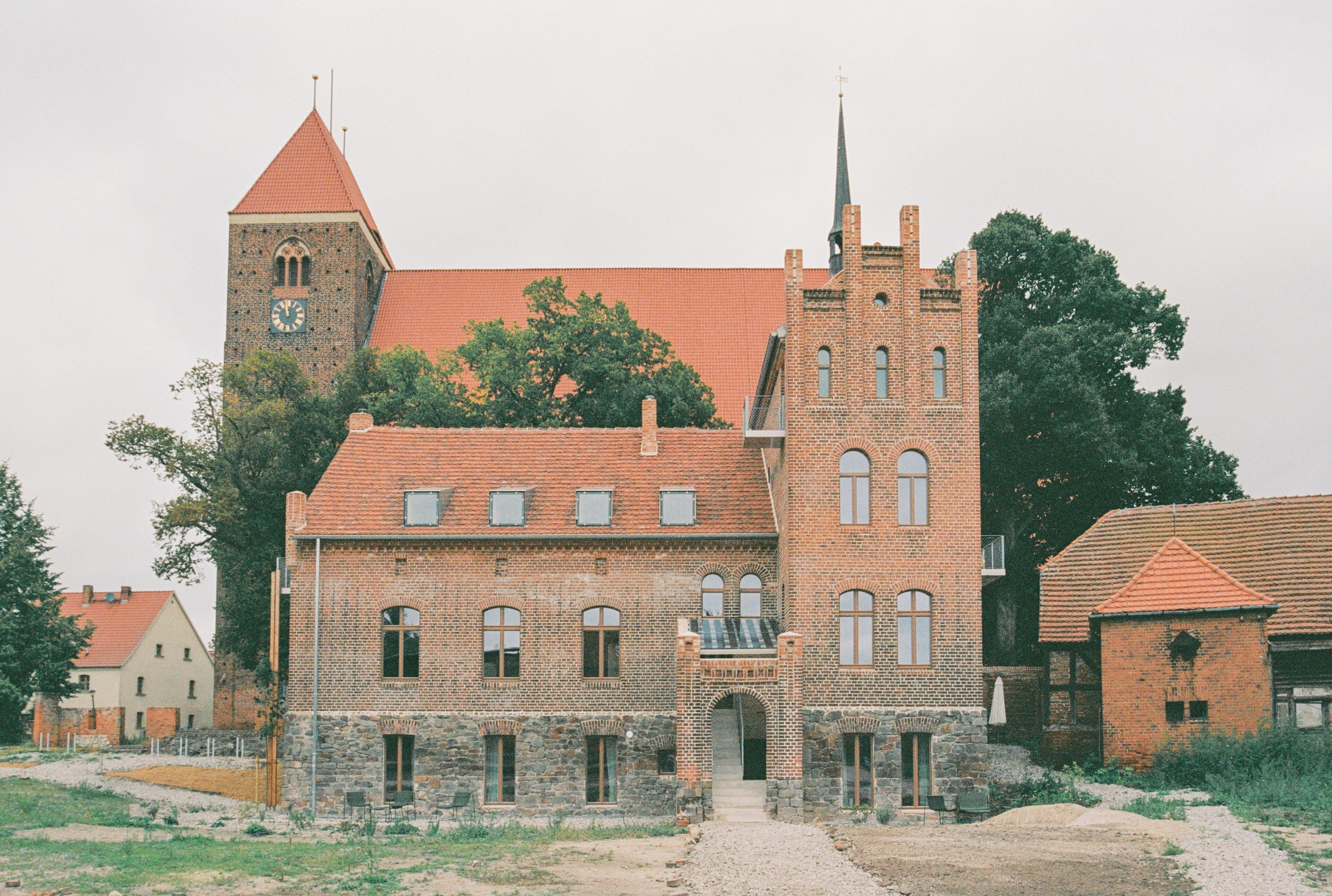 A historic building with a prominent tower and arched windows, featuring a traditional brick facade and a central entrance.