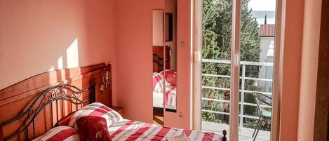 Una camera da letto con un letto, una finestra e vista sul verde.