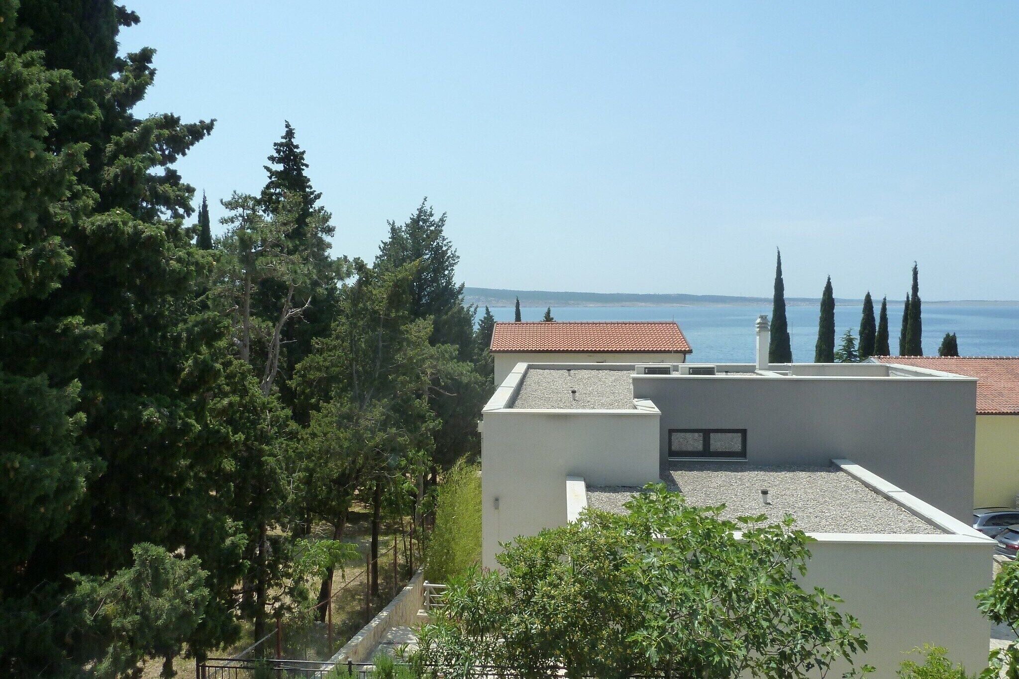 A modern building with a flat roof and a view of the sea.