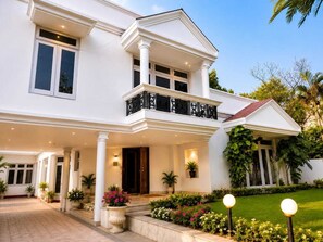 A two-story house with a balcony, a front porch, and a well-maintained garden. - Regalia Home (Jammu)