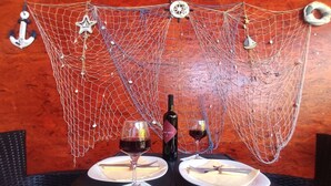 A table set with two wine glasses, a bottle of wine, and plates with cutlery.