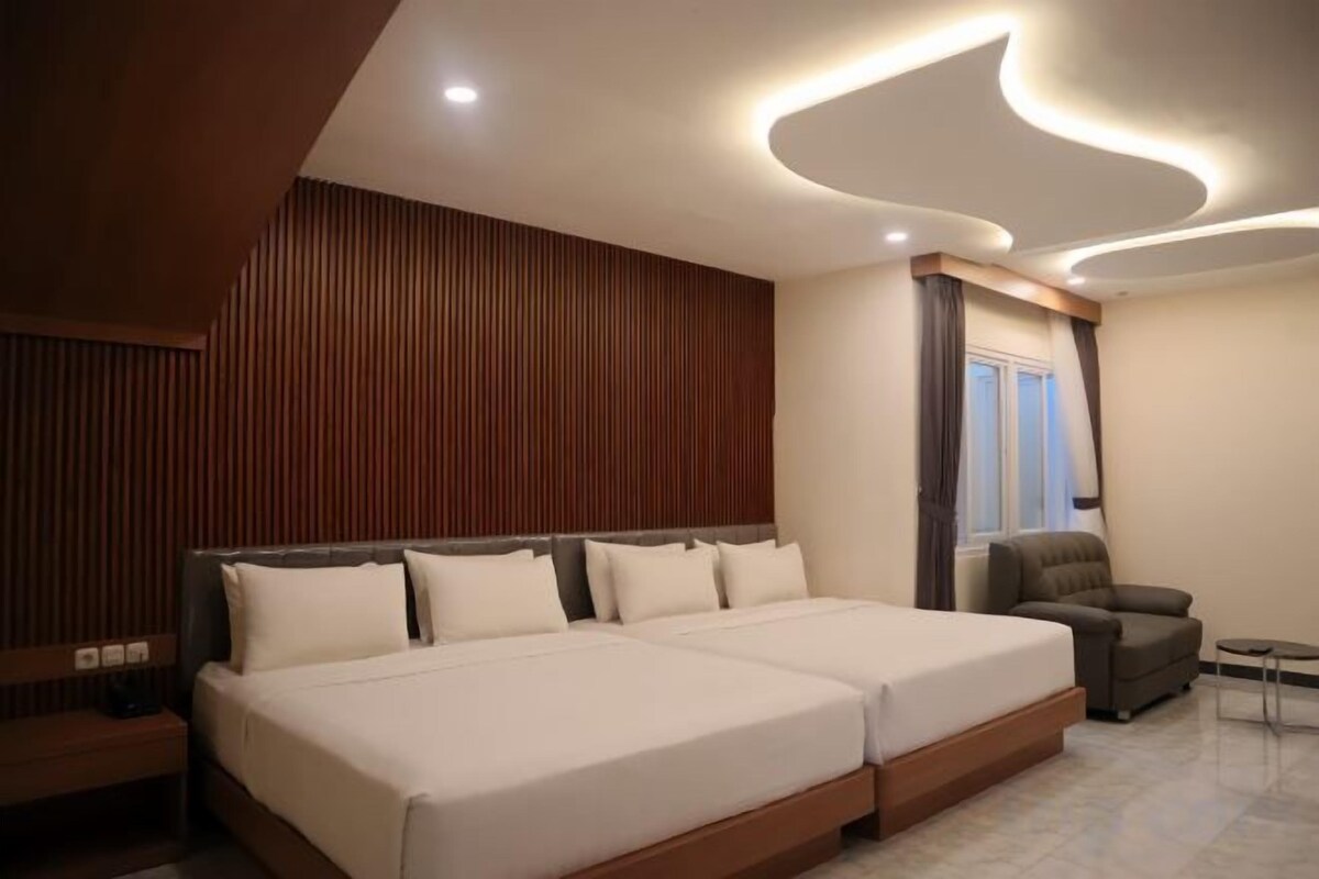 A modern bedroom with a large bed, a chair, and a small table.