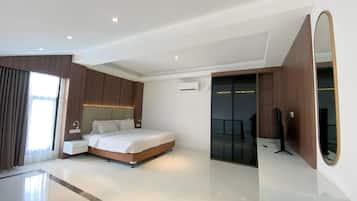 Habitación de hotel moderna con una cama grande, un tocador con espejo y un vestidor.