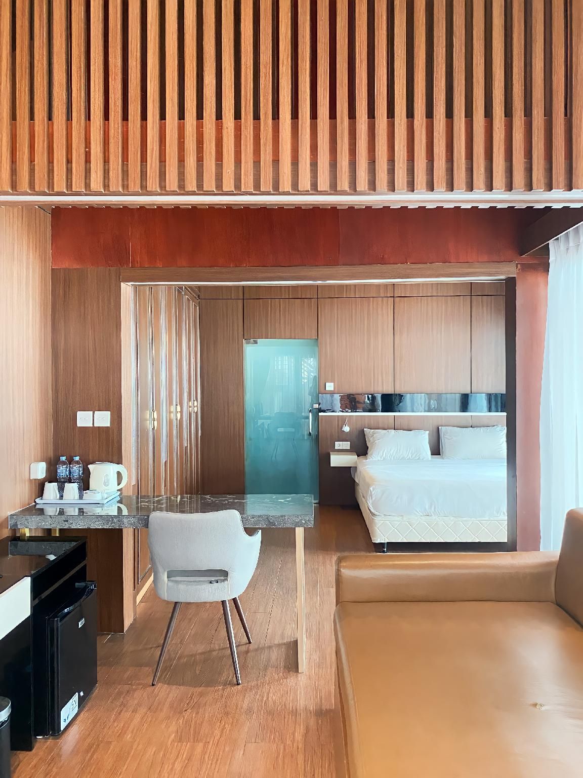 Habitació d'hotel moderna amb cuineta, zona de menjador i un llit.