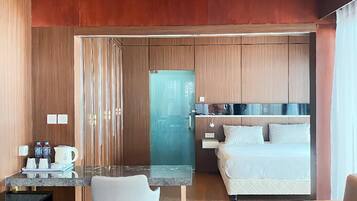 Habitació d'hotel moderna amb cuineta, zona de menjador i un llit.