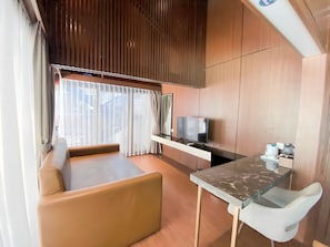 A modern living area with a sofa, a TV, and a small table.