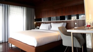 Una habitación de hotel con una cama grande, un escritorio y una silla.