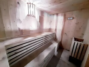 A room with a wooden bench, a radiator, and a small table. - Shakti Villa Dago (Coblong)