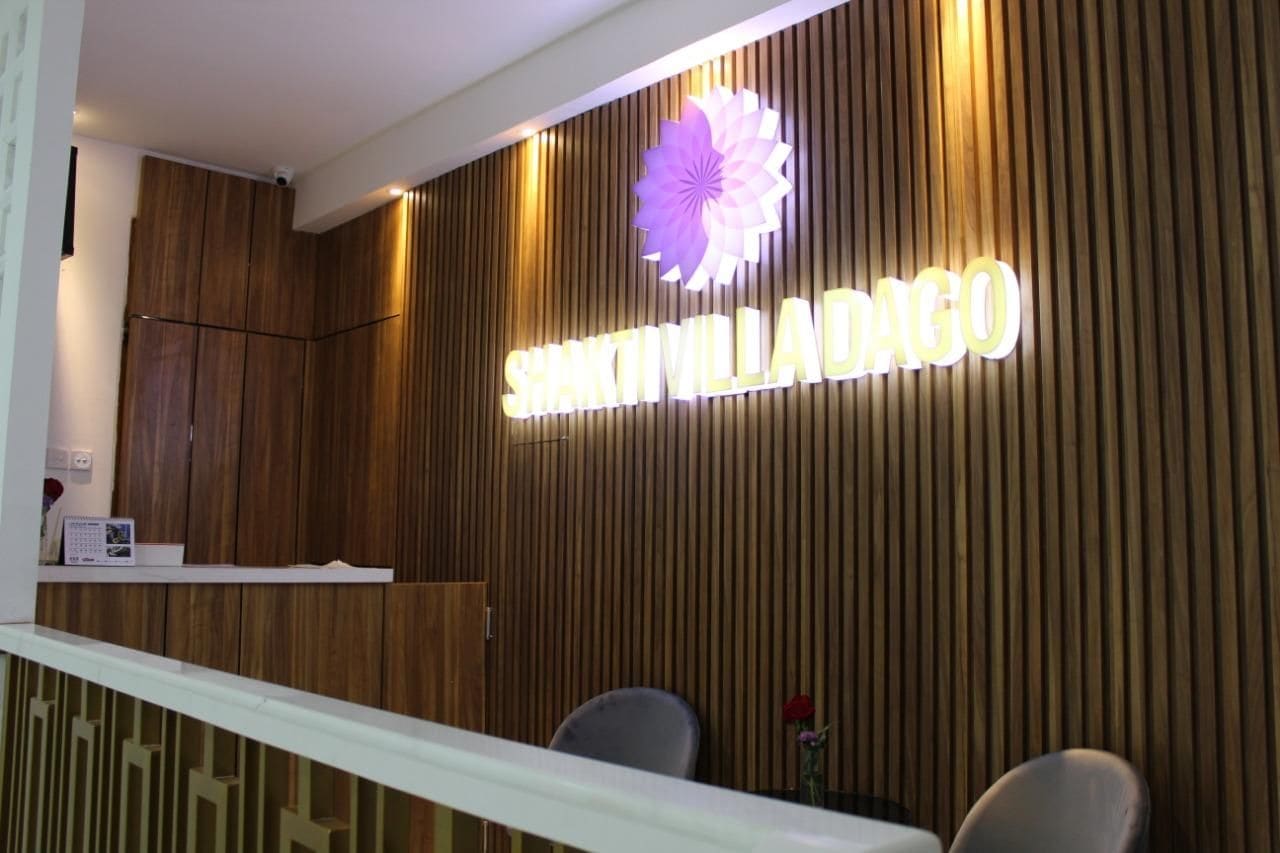 A reception desk with a wooden panel wall and a sign that reads 'SHAKTI VILLADANGO'.