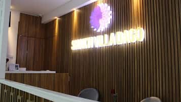 Una recepción con un panel de pared de madera y un cartel que dice 'SHAKTI VILLADANGO'.