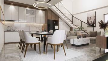 Ein modernes Interieur mit Essbereich, Küche, Treppe und Wohnbereich.