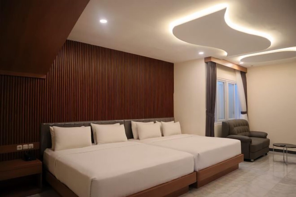 Une chambre à coucher moderne avec un grand lit, une table de chevet, une chaise et une petite table.