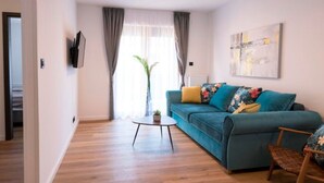 A living room with a sofa, a coffee table, and a painting on the wall.
