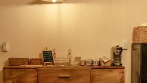 A wooden dresser with drawers, a coffee maker, and a chalkboard with writing. - Canaan Beach Home (Phu Quoc Island)