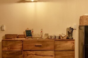 A wooden dresser with drawers, a coffee maker, and a chalkboard with writing. - Canaan Beach Home (Phu Quoc Island)