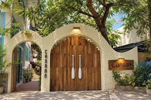 A wooden door with a sign reading 'Canaan' and two white paddles hanging on the wall above it. - Canaan Beach Home (Phu Quoc Island)