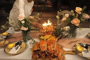 A dining table with seafood, flowers, and candles. - Canaan Beach Home (Phu Quoc Island)