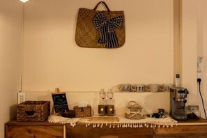 A kitchen counter with a coffee machine, mugs, a chalkboard sign, and a hanging bag. - Canaan Beach Home (Phu Quoc Island)